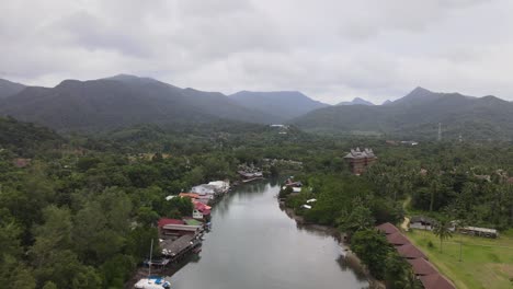 Aerial-view-of-river-and-mountainous-scenery,-tilt-up-reveal-shot