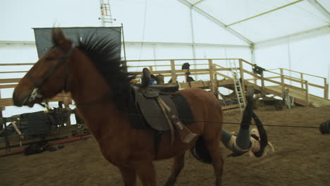 Stuntwoman-bucked-off-horse-during-rehearsal-stunt-with-flying-harness,-Slowmo