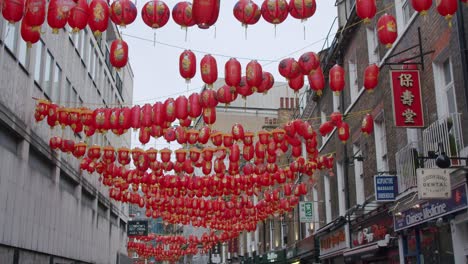 Slow-motion-gimbal-pan-of-Chinatown's-Chinese-lanterns-swaying-in-the-wind-on-an-overcast-London-day