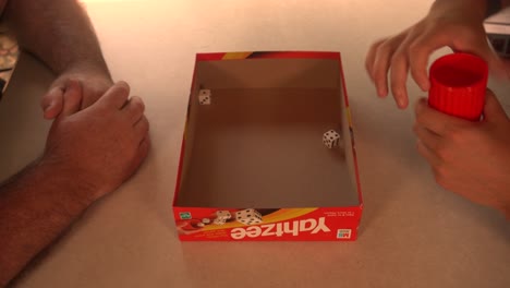 Man-rolling-dice-on-small-table-during-game