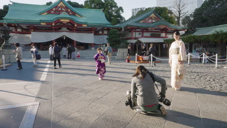Mother-And-Daughter-Wearing-Kimono-Dress-Having-Their-Photos-Taken-By-A-Photographer-At-The-Foreground-Of-Hie-Shrine-In-Tokyo,-Japan