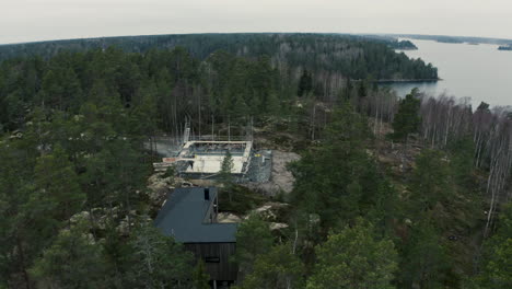 Modern-house-being-built-on-mountain-in-the-Stockholm-archipelago,-aerial