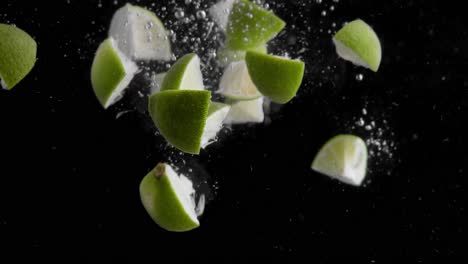 Lime-Slices-Falling-into-Water-Super-Slowmotion,-Black-Background,-lots-of-Air-Bubbles,-4k240fps