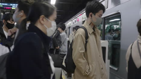Commuters-Wearing-Facemask-Getting-Inside-A-Train-On-Yamanote-Line-During-COVID-19-Pandemic-In-Tokyo,-Japan