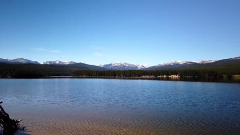 Time-lapse-of-Park-Reservoir-in-Bighorn-National-Forest-on-a-clear-summer-day-with-snow-covered-Clouds-Peak-in-the-background