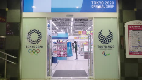 Cliente-Femenina-Comprando-Dentro-De-La-Tienda-Olímpica-En-Tokio,-Japón-Durante-La-Pandemia---Tiro-Medio,-Cámara-Lenta