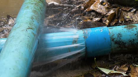 Close-up-shot-of-old-blue-PVC-pipes-leaking-water