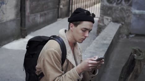 Young-man-writing-sms-on-his-mobile-phone