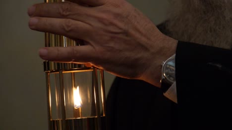 Close-up-of-a-priest-holding-a-lit-lantern-for-transfer-of-Holy-Fire-on-Easter-at-the-Church-of-Holy-Sepulchre