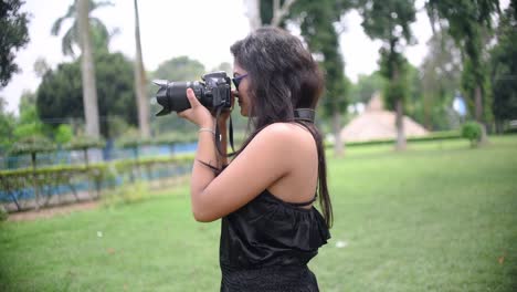 A-tourist-Asian-girl-takes-photograph-with-a-DSLR-camera-at-a-nature-park