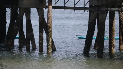 Three-kayakers-pass-by-a-pier-at-the-Ruston-Way-waterfront-in-Tacoma