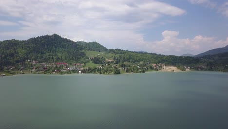 Aerial-Slow-rising-shot-of-lake---reservoir-with-mountain-range-in-the-background