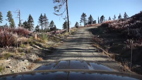 Handheld-Footage-of-Truck-Driving-up-Gravel-Road-to-a-Mountain-Bike-Trail-in-the-Late-Summer