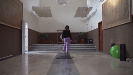 Mädchen-Machen-Yoga-In-Der-Meditationshalle-Mit-Einem-Großen-Gong