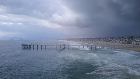 Aerial-pullback-of-an-ocean-storm-gathering-by-Manhattan-Beach-Pier,-California