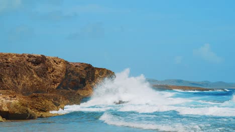 Waves-crashing-and-spraying-coral-boulders-on-Curacao-coast,-Slow-Motion