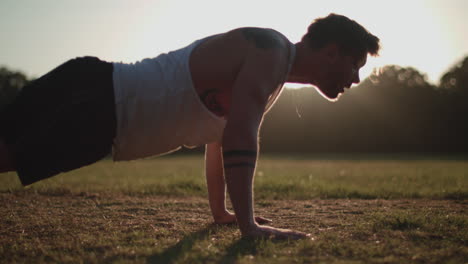 Man-Doing-Press-Ups-In-The-Park-In-The-Evening-Sun