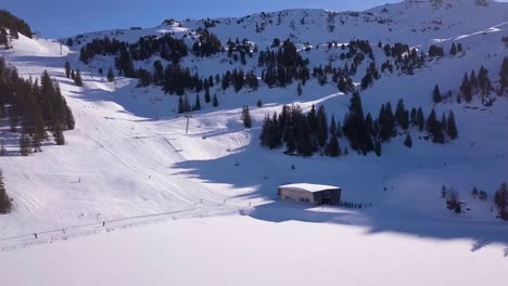 Drohnenaufnahme-Von-Wintersportlern,-Die-Einen-Hügel-Hinunterfahren-Und-Zum-Sessellift-Gelangen
