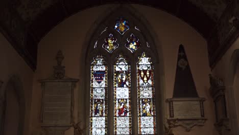 Tilt-pan-inside-old-church-with-stained-glass-and-ornate-ceiling