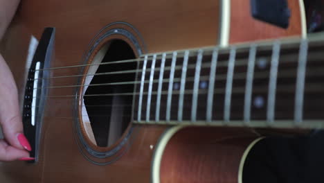 Woman-strumming-metal-string-acoustic-guitar.-Close-up