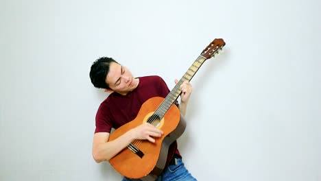 Chico-Asiático-Interpreta-Una-Canción-De-Rock-Con-Su-Guitarra-Acústica-Vintage