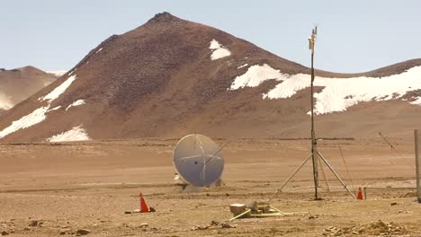 A-wide-shot-of-a-small-telescope-at-the-alma-observatory,-with-the-Andes-mountains-behind-it