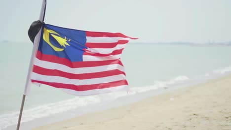 Eine-Nationalflagge-Von-Malaysia,-Die-An-Der-Windigen-Küste-Flattert