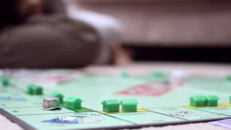 Ground-level-view-of-children-and-adults-playing-the-classic-board-game-Monopoly