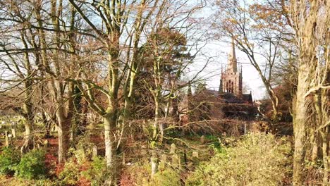 Linksschwenk-Durch-Herbstlaublose-Bäume-Hindurch-Zum-Kirchhof---Kirche-Im-Hintergrund