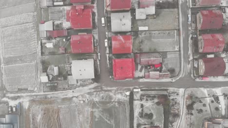Top-down-overhead-Aerial-over-houses-with-red-roofs-during-snow-storm