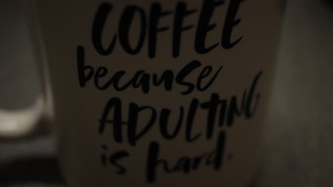Dolly-into-focus-close-up-of-coffee-cup-with-saying-on-it