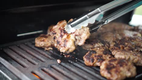 Chef-turns-over-meat-on-barbeque