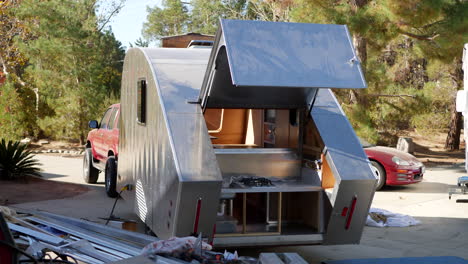 Slide-left-along-a-construction-site-where-they-are-building-a-metal-custom-teardrop-travel-trailer-to-take-on-a-camping-roadtrip