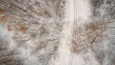 Drone-footage-over-the-snowy-railway-in-the-woods