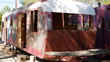 Slide-right-revealing-a-dirty-old-damaged-vintage-metal-travel-trailer-in-the-middle-of-a-restoration-and-rebuild-process