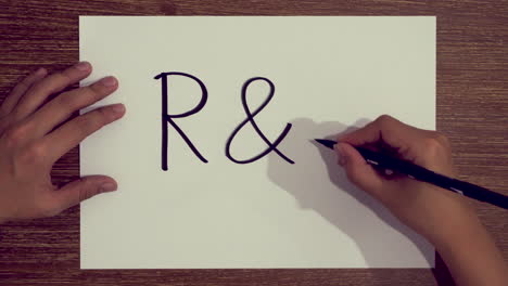 Hand-writing-the-word-R-D-on-paper-using-brush-pen-marker
