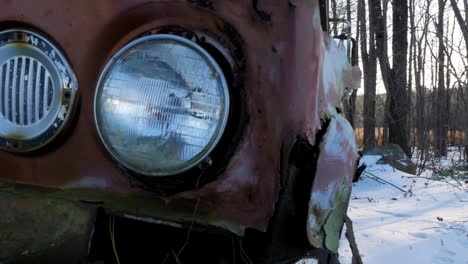 Close-Up-Old-Rusted-Car-in-a-Snowy-Forest