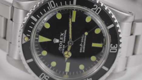 Panning-footage-of-a-collected-luxury-watch,-Rolex-Submariner,-on-a-white-background
