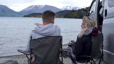 SLOWMO---Young-couple-eating-lunch-at-motorhome-by-Lake-Wakatipu,-Queenstown,-New-Zealand---Close-Up