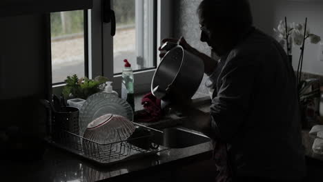 Rentner-Beim-Abwaschen-Am-Fenster,-Silhouette