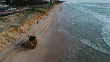 Heavy-machinery-picking-up-rubbish-from-a-beach-that-was-damaged-by-a-recent-cyclone