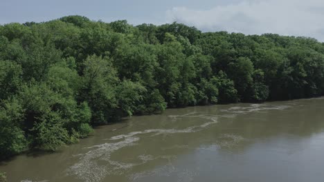 Drone-smoothly-flies-above-a-rolling-river-in-the-Midwest-USA