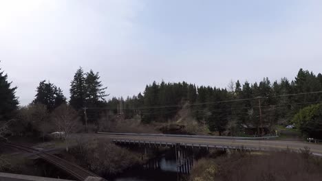Driving-down-101-in-Oregon-with-a-view-of-a-curved-road-with-a-bridge-going-over-a-river
