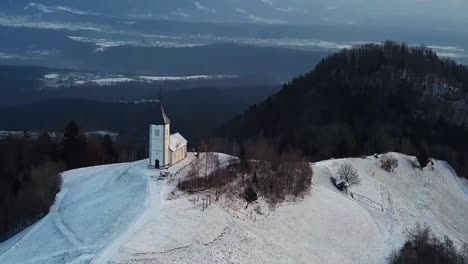 Blick-Auf-Die-Kirche-Von-Jamnik-In-Einer-Winterlandschaft-Mit-Farbenfrohem-Sonnenaufgang-In-Kranj,-Slowenien