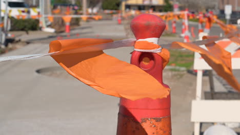 Orangefarbene-Flaggen,-Die-Vom-Wind-Wehen,-An-Den-Seilen-Auf-Kegelzäunen-Mit-Gestreiftem-Klebeband-Befestigt,-Um-Die-Straße-Während-Der-Renovierungszeit-Zu-Trennen,-Sicherheit-Zuerst-Verkehrszeichen