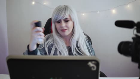 Female-video-blogger-is-reviewing-cosmetics-in-front-of-a-professional-camera
