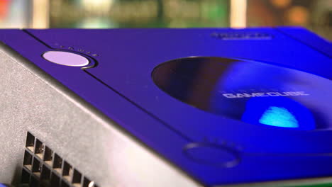 Öffnende-Oberseite-Des-Nintendo-Gamecube-Mit-Disc-Im-Inneren-Und-Farbeffektfolie-Rechts