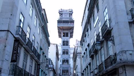 Eine-Glatte-Ansicht-Von-Unten-Nach-Oben-Für-Den-Aufzug-Von-Santa-Justa-In-Lissabon,-Portugal-An-Einem-Sonnigen-Tag-Mit-Touristen-Oben,-Die-Die-Aussicht-Auf-Die-Stadt-Fotografieren-Und-Genießen