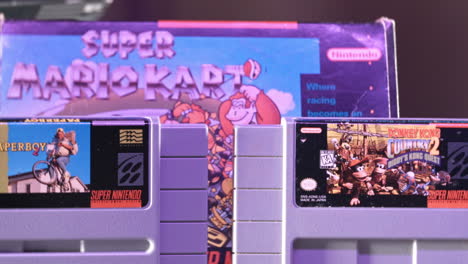 Vintage-Super-Nintendo-Cartridges-with-Box-in-Background-in-Purple-Light-SLIDE-RIGHT