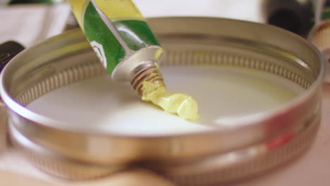 Artist-Squeezing-Out-Yellow-Paint-On-Paint-Tube